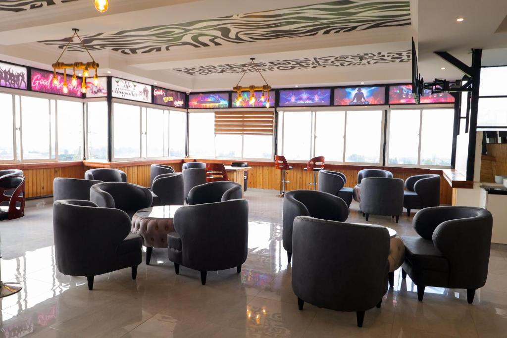 a waiting room with chairs and a table and windows at Maraluxe Resoert & Spa in Nakuru