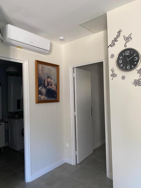 a clock on a wall next to a hallway at Era in Chancelade