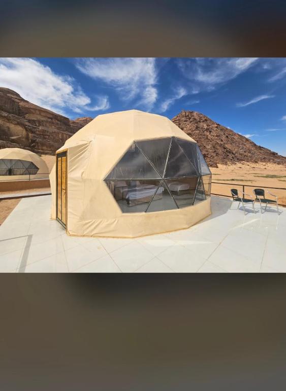 a tent with chairs in front of a desert at Wadi rum desert sky in Wadi Rum