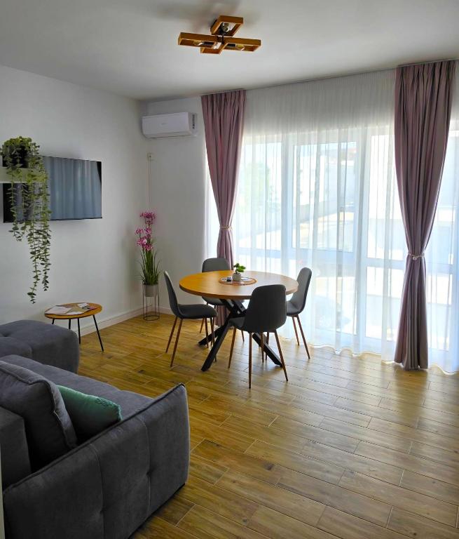 a living room with a couch and a table and chairs at Sakura Residence Felix in Sînmartin