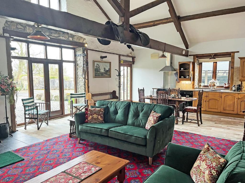 a living room with a green couch and a table at The Barton in Launceston