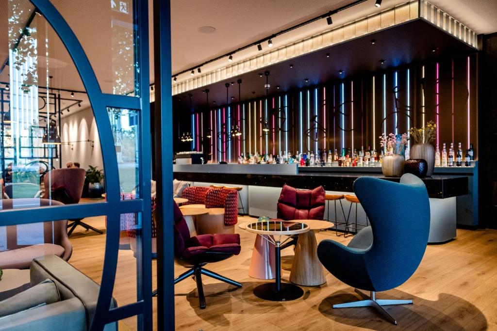 a lobby with a bar with chairs and tables at Motel One Amsterdam in Amsterdam