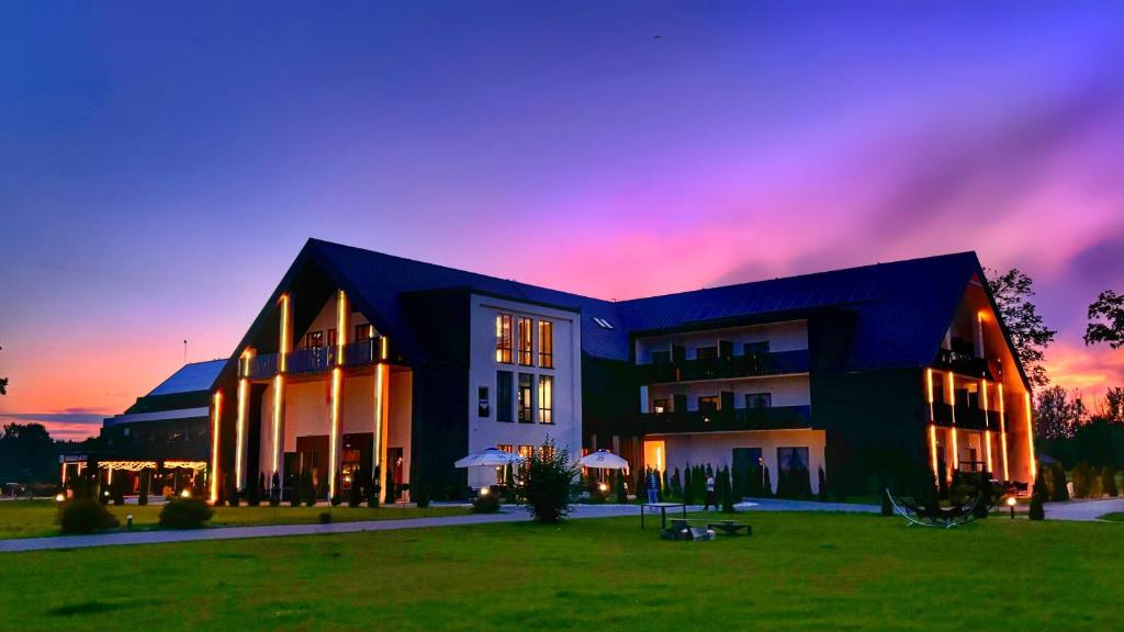 un grande edificio con un tramonto sullo sfondo di Natural Hotel przy plaży-Ostróda-basen na III kondygnacji a Ostróda