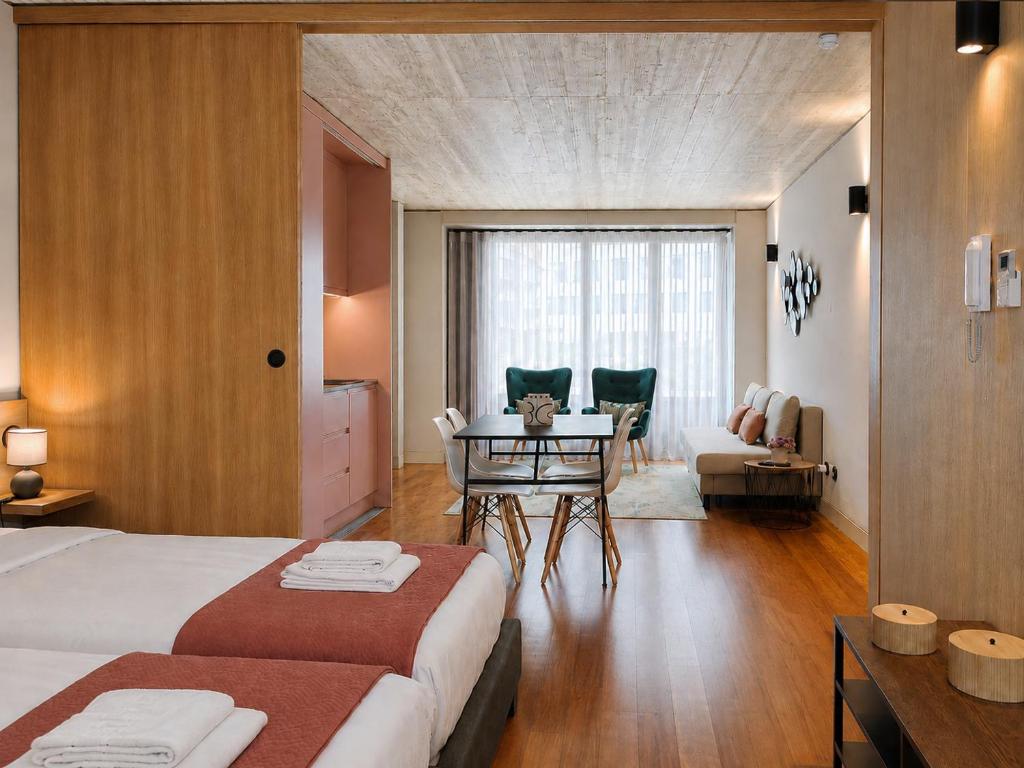 a bedroom with a bed and a table and a couch at Fervença Apartments in Vila Nova de Gaia
