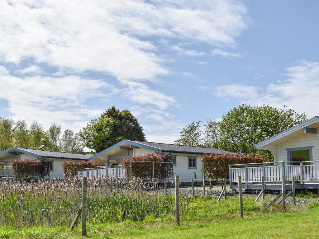 a house with a fence in front of it at Pine Lodge - Uk30007 in Lindal in Furness