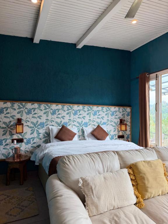 a blue bedroom with two beds and a couch at MATANAI HOUSE X THHP - The Deck Villa Mukteshwar - 2 Bedroom Bonfire & BBQ in Mukteshwar