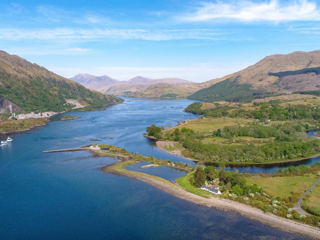 an aerial view of a river with mountains in the background at Point Park in Taynuilt