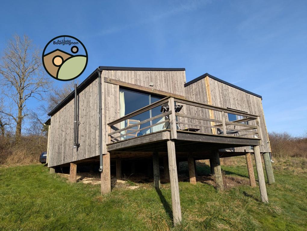 a wooden house on a hill with a frisbee at Au Chalet Bourguignon 5 in Salives
