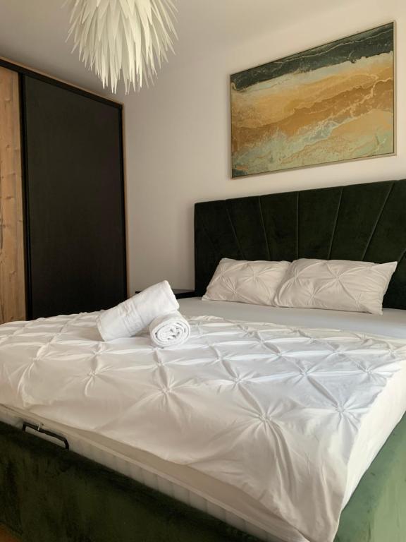 a large white bed with a black headboard in a bedroom at Luxury Central Monarch Residence Apartment Sleeps 5 in Timişoara