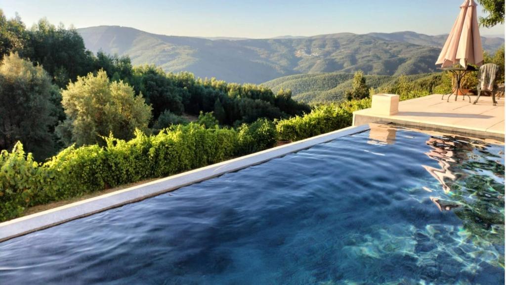 a swimming pool with a view of the mountains at Lugar dos Meandros 