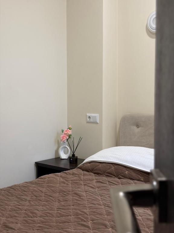 una camera da letto con un letto e un tavolo con dei fiori sopra di Hotel Sofiyvka Park a Umanʼ