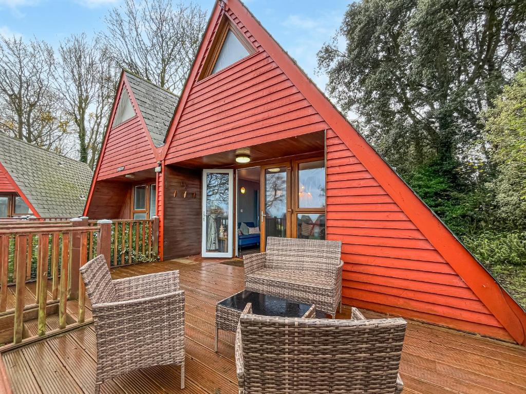a red roofed house with chairs on a deck at Lodge 64 in Kingsdown