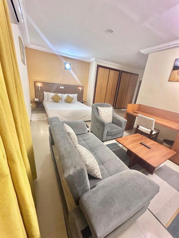 a room with a couch and a bed and a table at Le Ranch Hôtel San-Pedro in San-Pédro