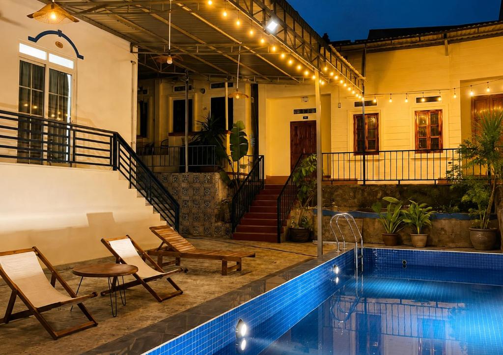 a house with a swimming pool and two chairs next to a house at VitaSea Mui Ne homestay & pool in Mui Ne