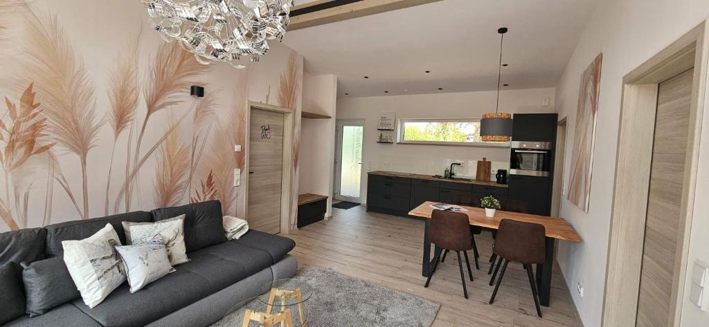 a living room with a couch and a table at Gartenbungalow Rhönwald in Hilders