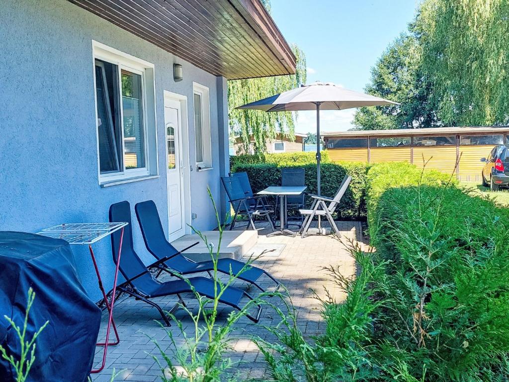a patio with a table and chairs and an umbrella at Holiday Home Goetheallee by Interhome in Krakow am See