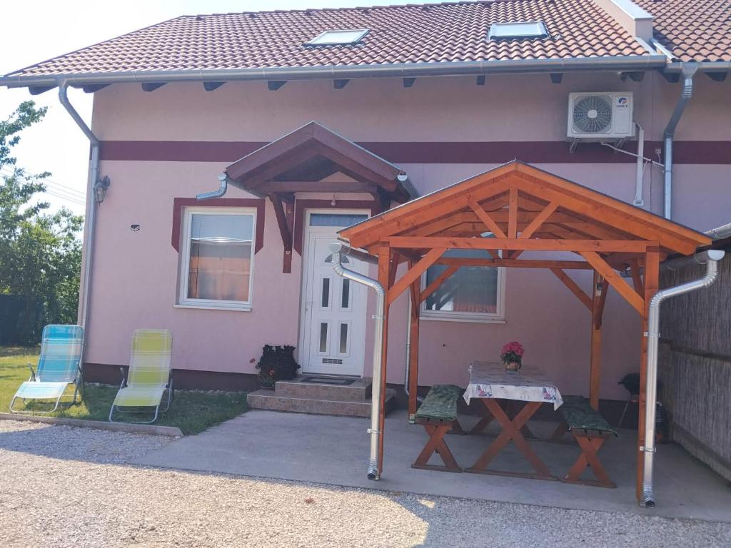 a house with a table and chairs in front of it at Kötél utcai vendégház in Balatonkeresztúr