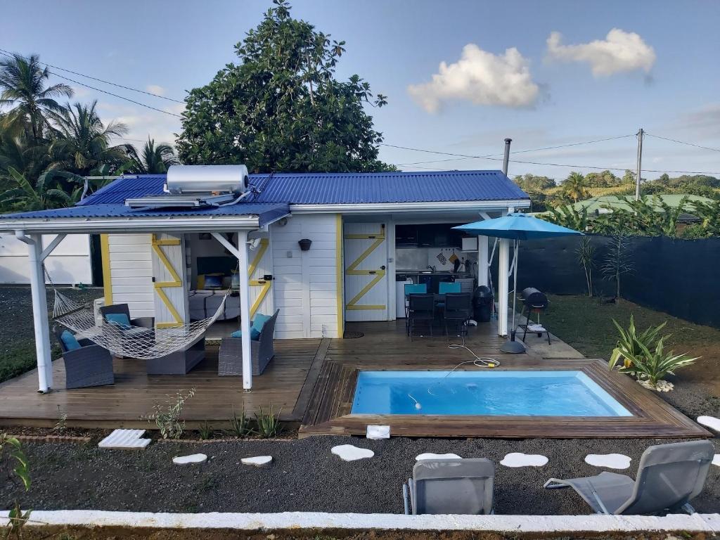 a house with a swimming pool in the backyard at Bungalow chic à Sainte-Rose + piscine. in Sainte-Rose