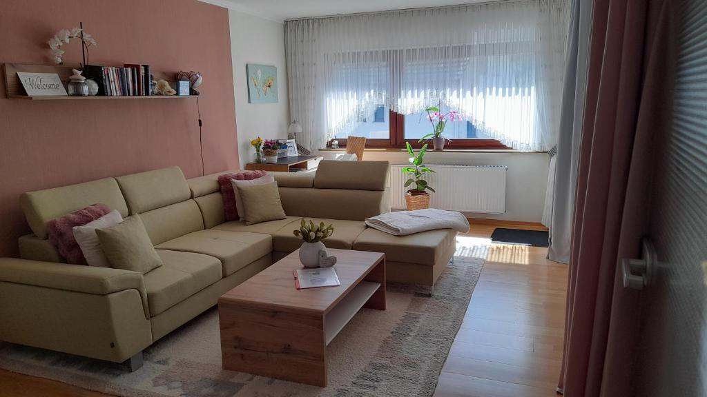 a living room with a couch and a table at Ferienwohnung " Am Dorfbrunnen" in Dienethal