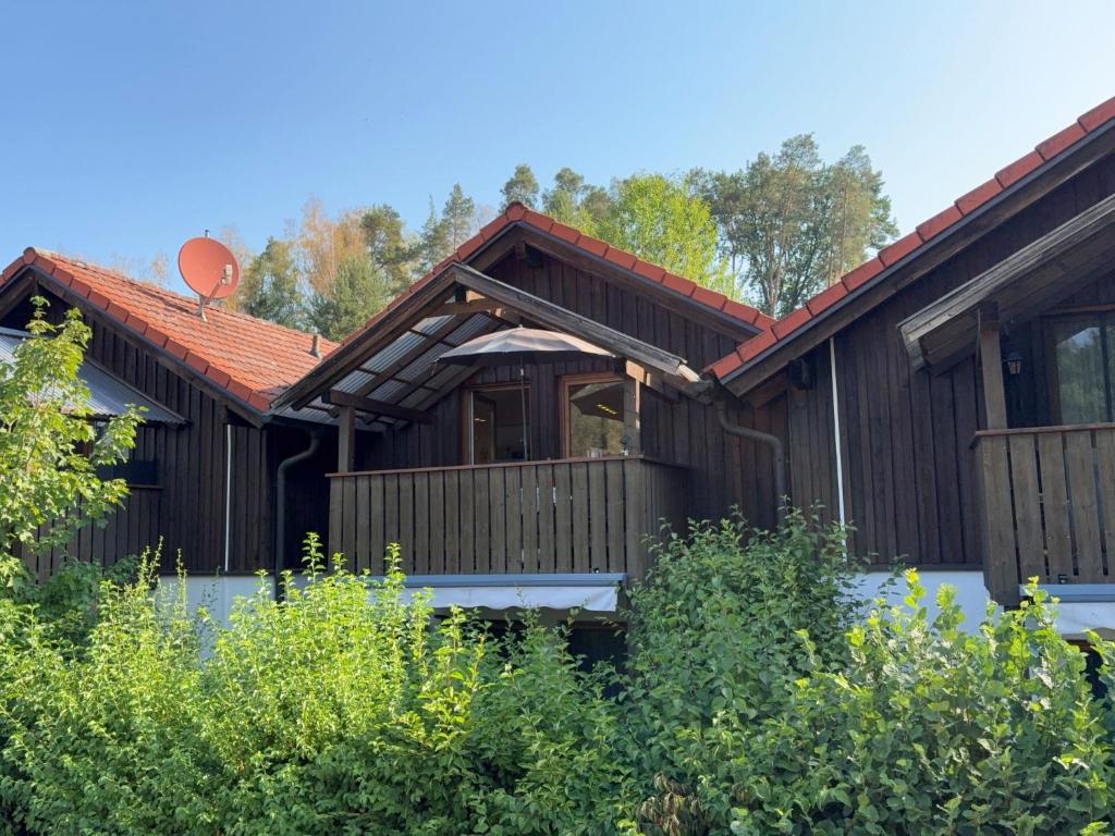 a wooden house with a deck in a yard at Apartment Petra by Interhome in Grafenwiesen
