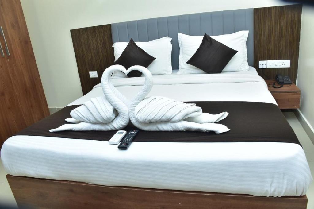 a bed with two swans made out of towels at Hotel safal exotica in Puri