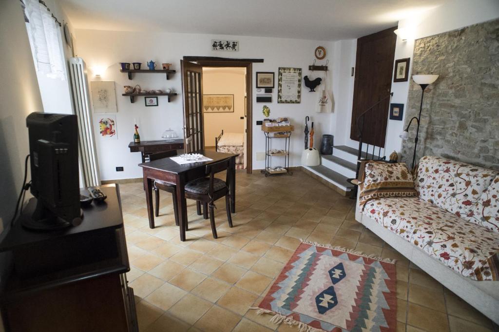 een woonkamer met een bank en een tafel bij Archi del '400 Appartamento in Barolo