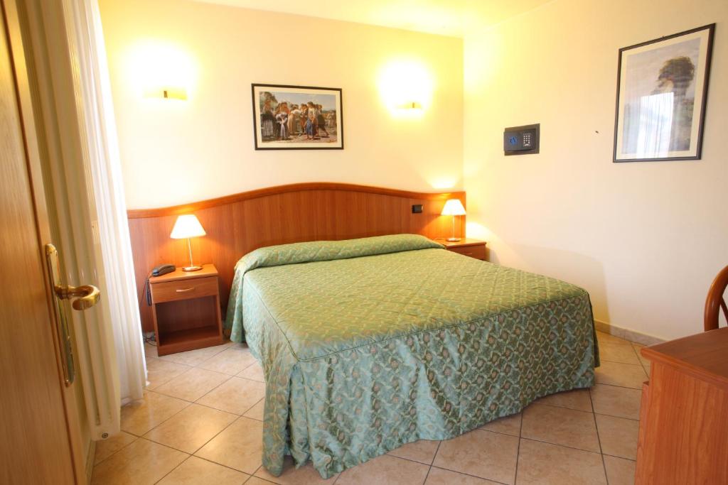 Łóżko lub łóżka w pokoju w obiekcie Albergo Alla Campana