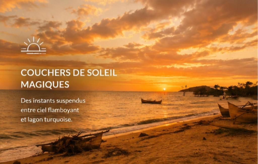 a sunset on a beach with a boat in the water at Les Bungalows De Ja in Nosy Be