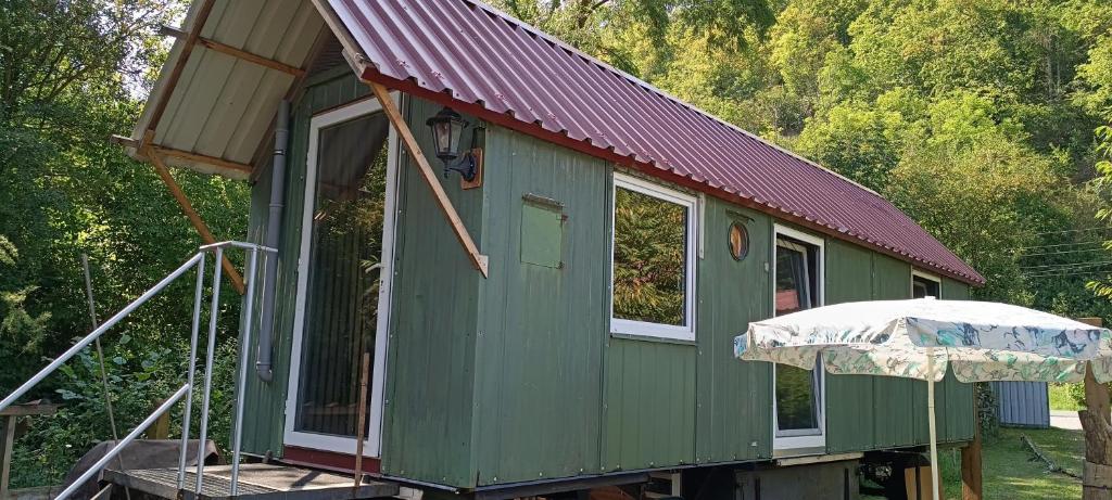 a green house with a red roof and an umbrella at Tinyhaus in Dornburg