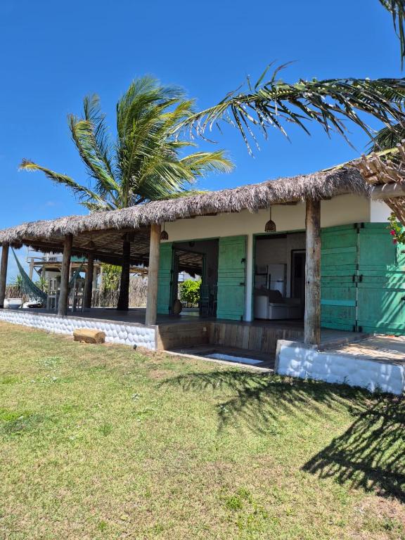 a house on the beach with a palm tree at Villa Água Viva in Itarema