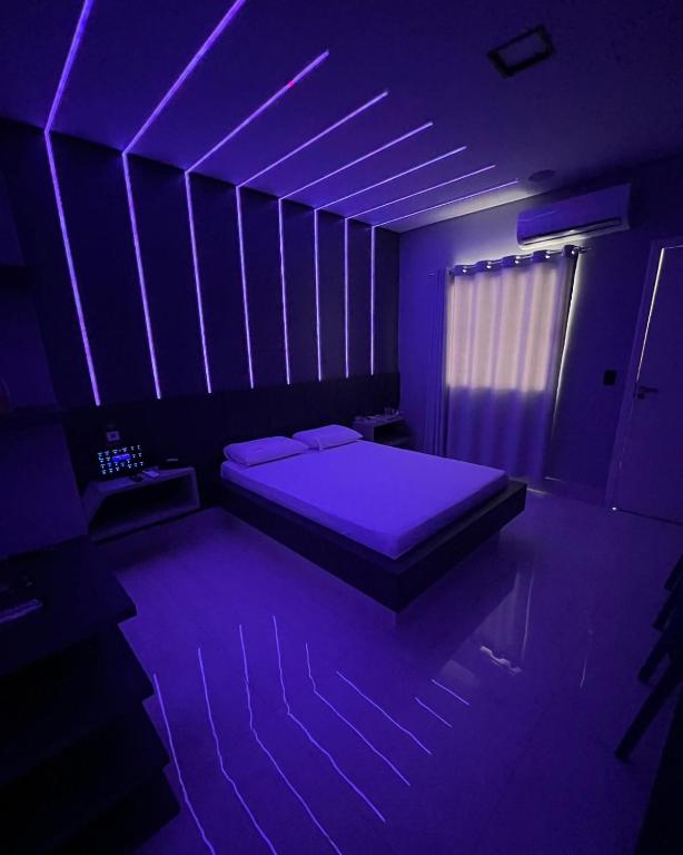 a room with a bed with a purple lighting at Luxus Motel Caldas do Jorro in Tucano