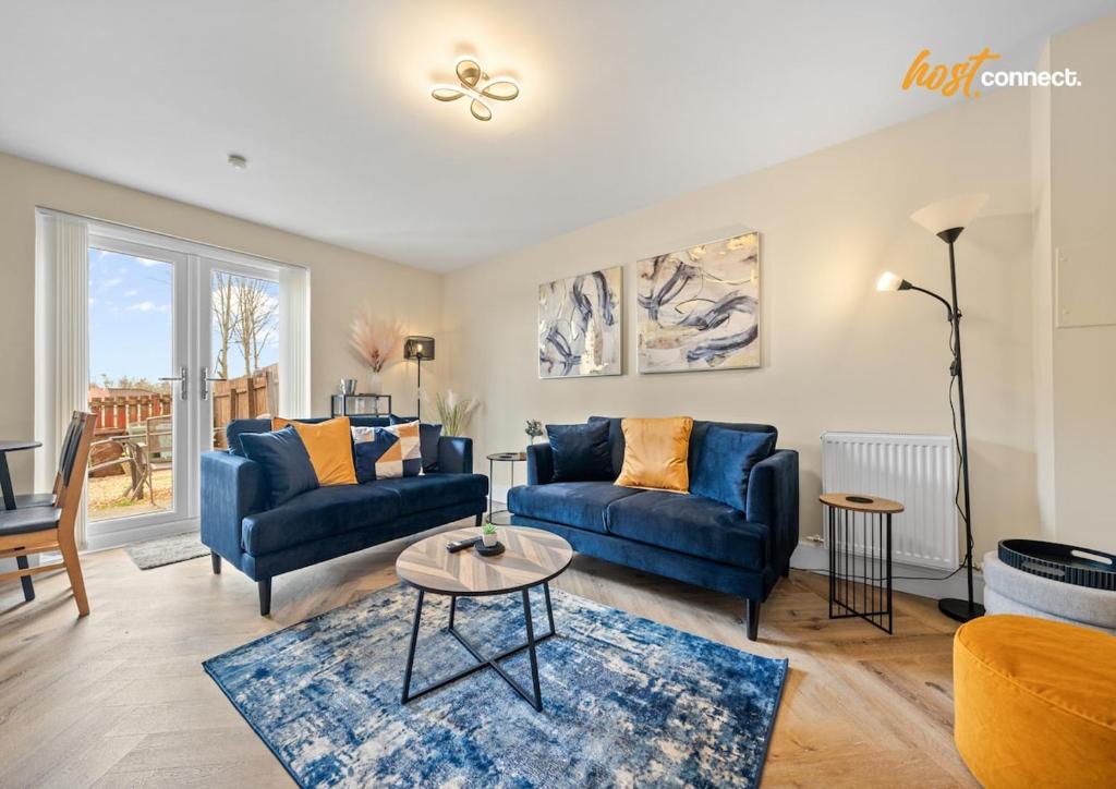 a living room with two blue couches and a table at 2Br House I Sleeps 4 I Cumbernauld in Cumbernauld