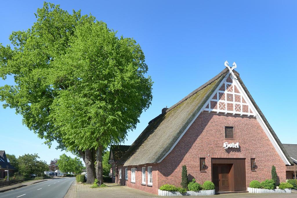 un antiguo edificio de ladrillo rojo con techo de paja en Landhotel Zur Eiche en Buxtehude