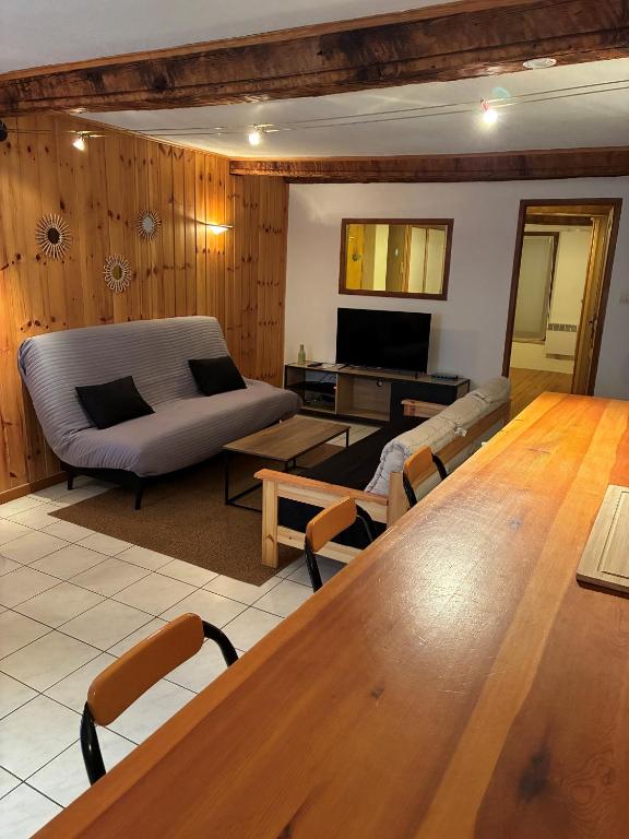 a living room with a table and a couch at Le cocon de Barcelonnette in Barcelonnette