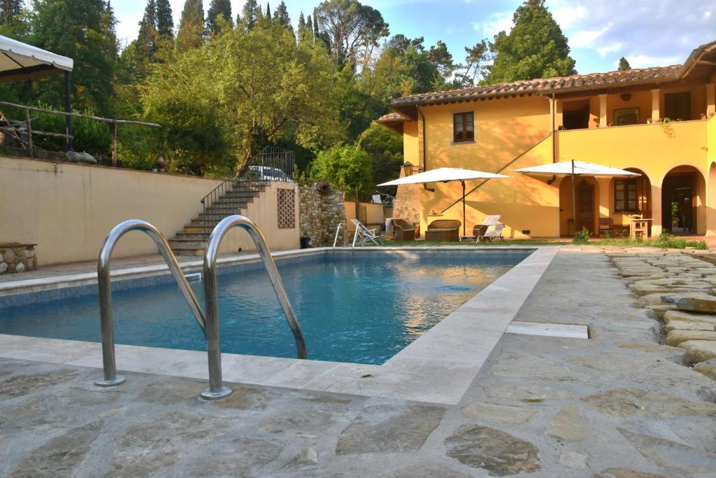 a swimming pool in front of a house at Hotel Sor Paolo in San Casciano in Val di Pesa