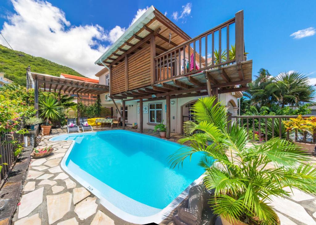 een huis met een zwembad en een balkon bij Blue Lagoon Villa in La Gaulette
