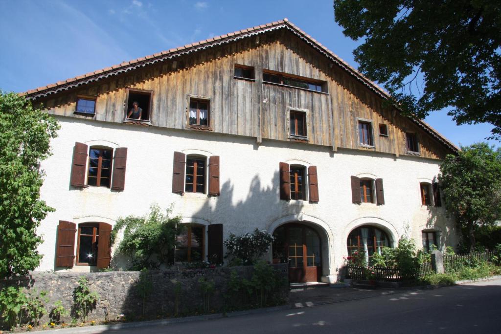 un grand bâtiment blanc avec un toit en bois dans l'établissement Le Polder, à Le Paquier