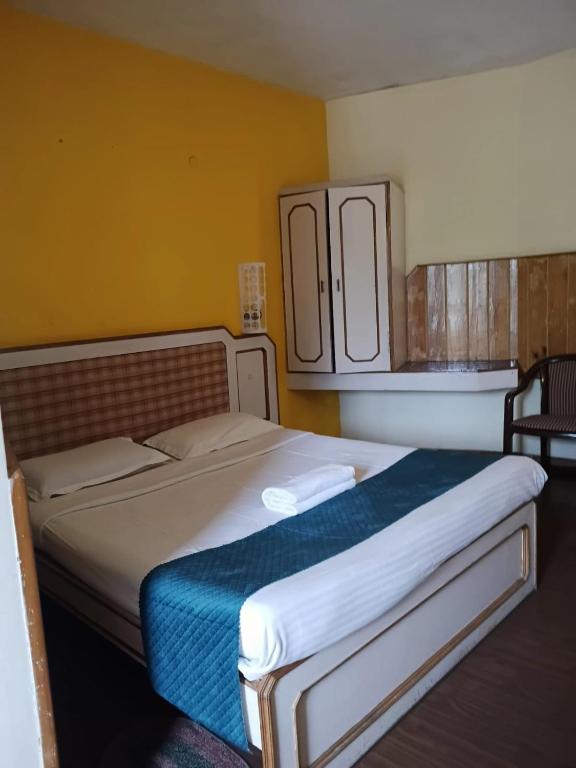 a bedroom with a large bed with a blue blanket at Hotel J'S Heritage in Kodaikānāl