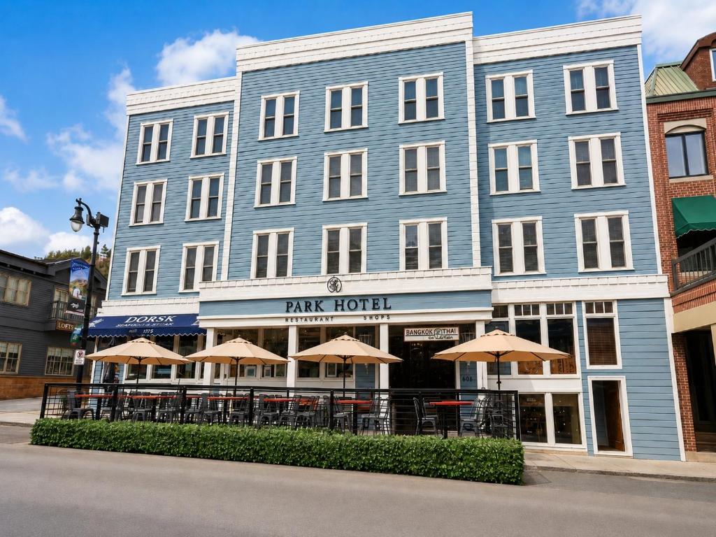 a large blue building with tables and umbrellas at Park Hotel Condominiums in Park City
