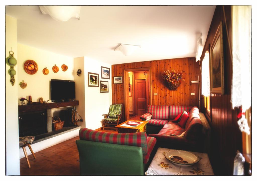 een woonkamer met een rode bank en stoelen bij Casa Mizzau in Camporosso in Valcanale