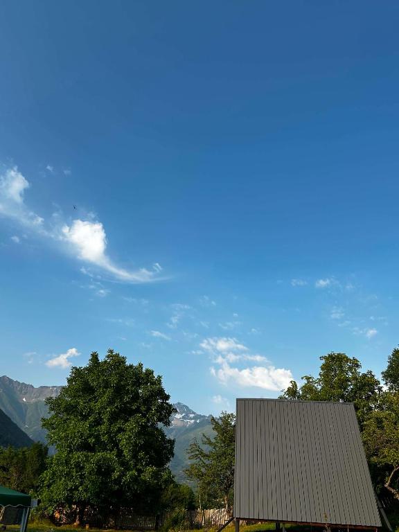 a house with a view of mountains and trees at khedi cottage in Mestia