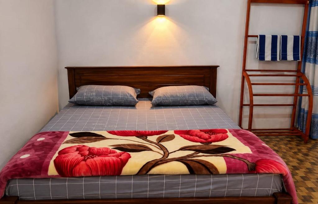 a bedroom with a bed with a blanket on it at RK guest in Nanu Oya