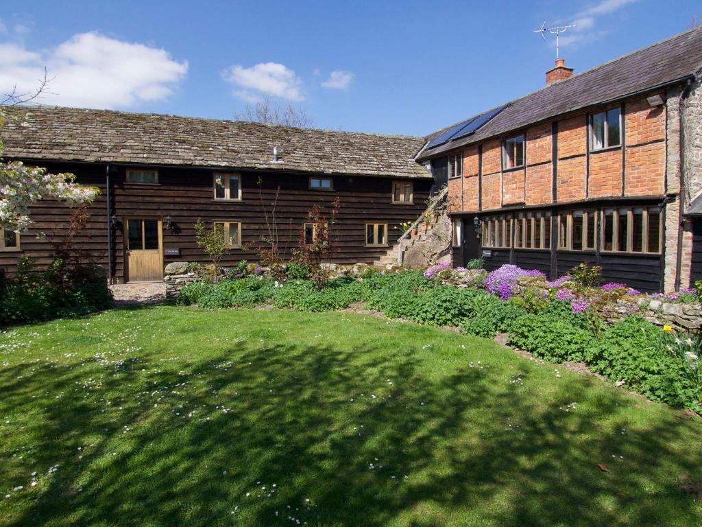 an old house with a garden in front of it at The Old Barn in Hereford