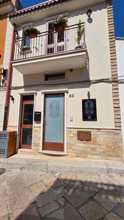 a building with a door and a balcony at Istmo Room and Breakfast in Lesina