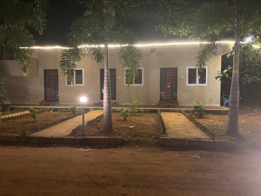 a building with palm trees in front of it at night at Holidaypark Resort Araku in Araku