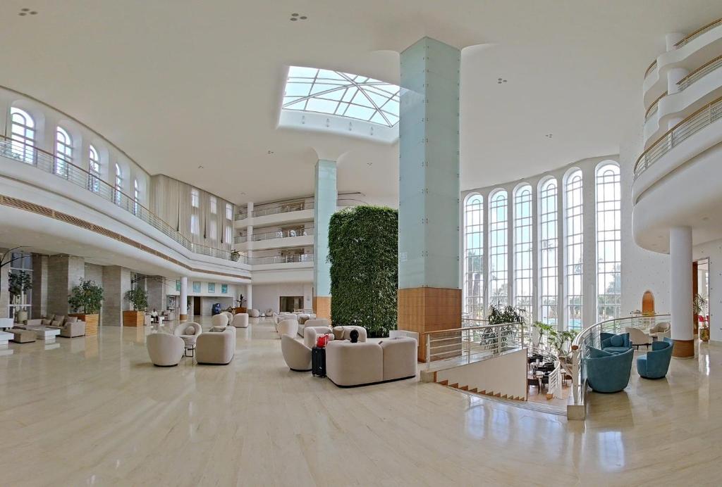 a large lobby with white furniture and large windows at LAICO Hammamet hotel in Hammamet