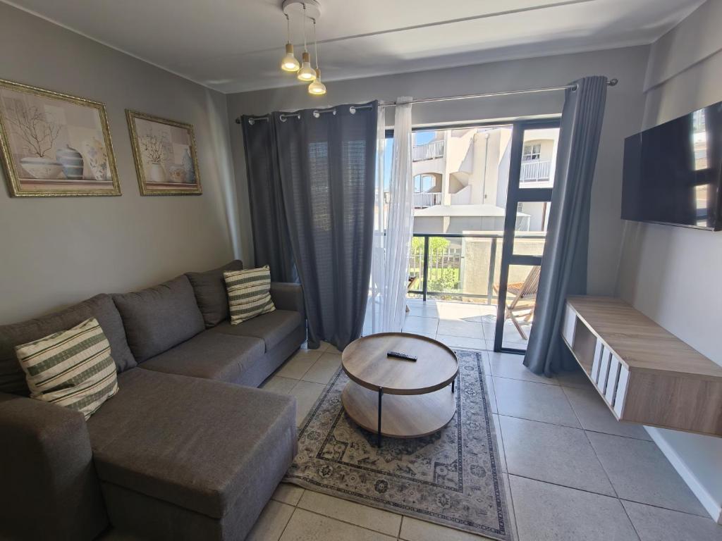 a living room with a couch and a table at 19 on Arch in Langebaan