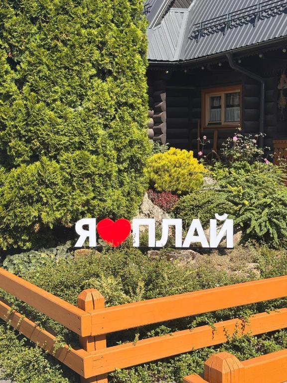 a garden with a sign in front of a house at Плай in Khmelnytskyi