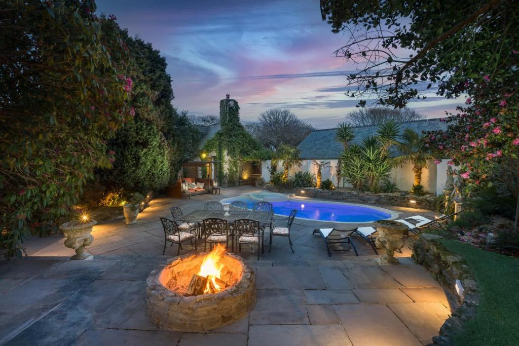 a patio with a fire pit and a swimming pool at Libertine in Breage
