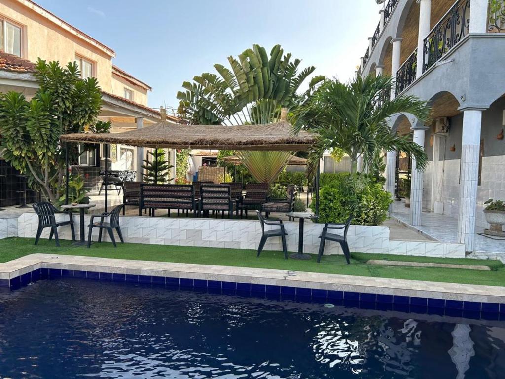 a patio with a table and chairs next to a pool at Jozene House in Ngaparou